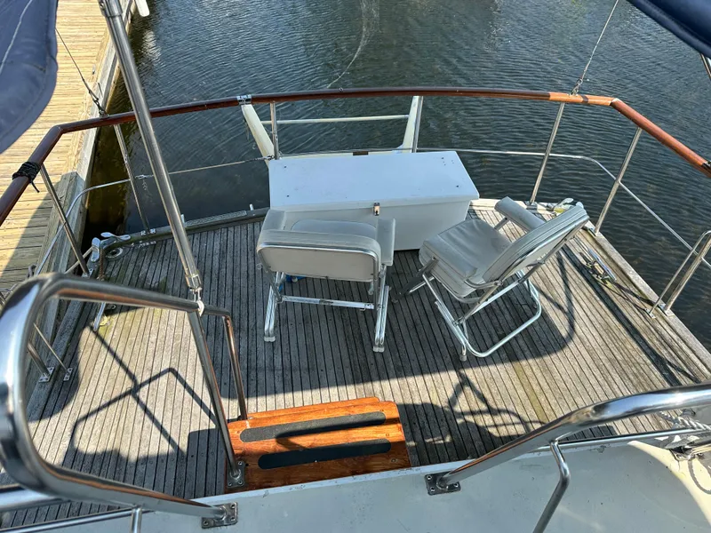 Slide: The Image of Aft deck of 1996 Island Gypsy 36 Aft Cabin with chairs and table, overlooking water. - 7