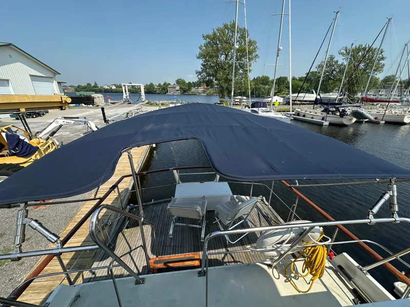 Slide: The Image of 1996 Island Gypsy 36 Aft Cabin yacht docked at marina with canopy and seating area. - 8