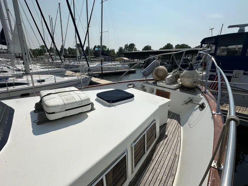 Slide: The Image of 1996 Island Gypsy 36 Aft Cabin yacht docked at marina, featuring spacious deck and nautical equipment. - 9
