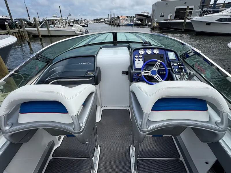 Slide: The Image of 2020 Formula 382 FASTech boat interior with dual seats and control panel at marina. - 12