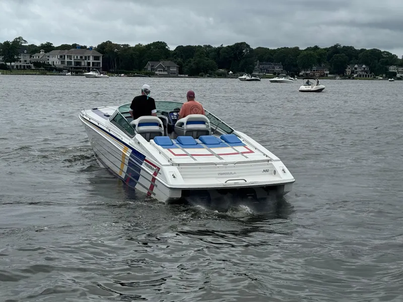 Slide: The Image of 2020 Formula 382 FASTech speedboat cruising on a lake with passengers, surrounded by houses and trees. - 6
