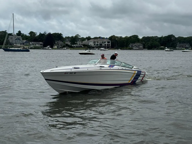 Slide: The Image of 2020 Formula 382 FASTech boat cruising on a lake with houses in the background. - 7