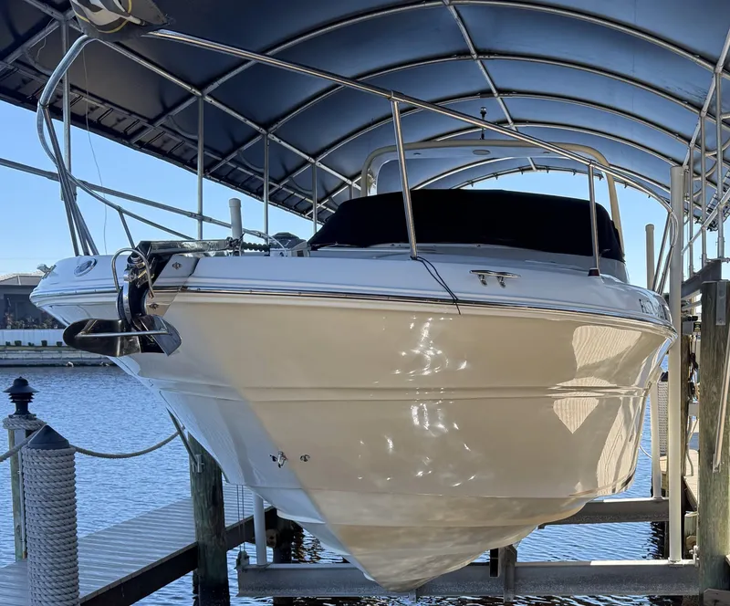 Slide: The Image of 1998 Sea Ray 310 Sundancer boat docked under a canopy. - 3