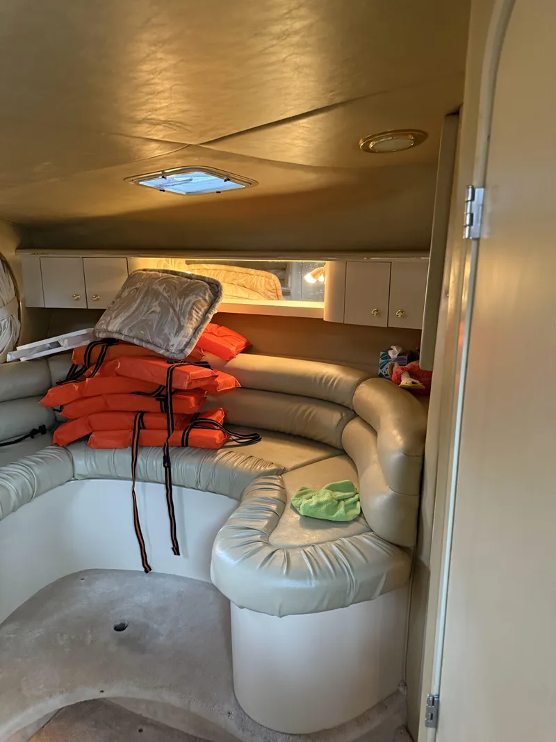 Slide: The Image of 1998 Sea Ray 310 Sundancer cabin interior with life jackets and seating area. - 6