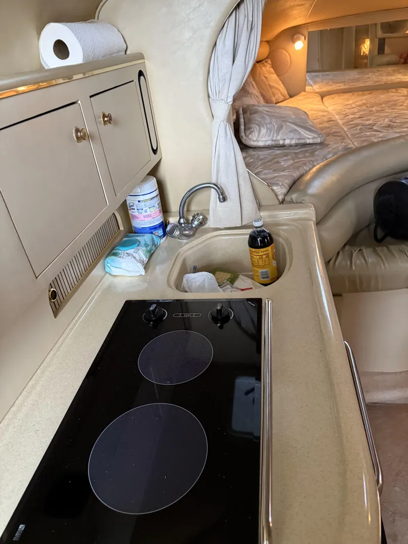 Slide: The Image of Interior of 1998 Sea Ray 310 Sundancer with kitchenette and cozy sleeping area. - 7