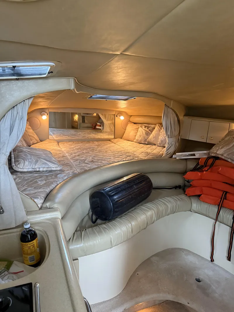 Slide: The Image of Interior of a 1998 Sea Ray 310 Sundancer boat with cozy sleeping area and safety equipment. - 8