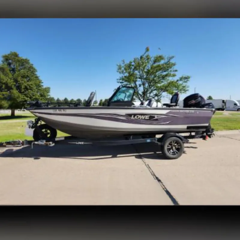 Slide: The Image of 2017 Lowe FM 1710 Pro WT fishing boat on trailer, parked outdoors. - 0