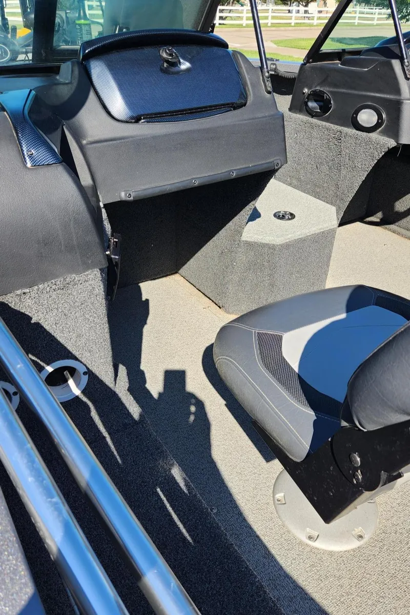 Slide: The Image of Interior of a 2017 Lowe FM 1710 Pro WT boat, featuring seating and dashboard. - 17