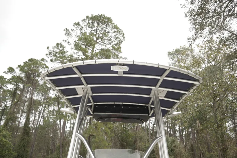 Slide: The Image of Tidewater 2200 Carolina Bay 2012 boat with T-top against forest backdrop. - 15