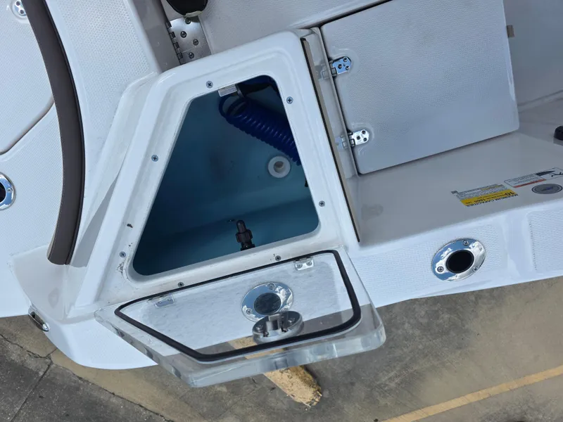 Slide: The Image of Open storage compartment on 2025 Yamaha Boats 222 FSH Sport E, featuring sleek design and functionality. - 15