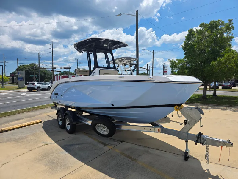 Slide: The Image of 2025 Yamaha Boats 222 FSH Sport E on trailer, parked outdoors under a cloudy sky. - 2