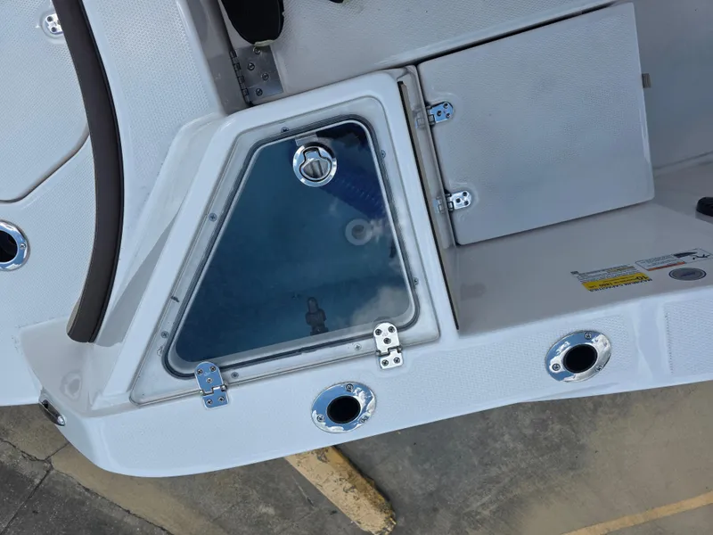 Slide: The Image of 2025 Yamaha Boats 222 FSH Sport E deck with storage compartments and rod holders. - 7