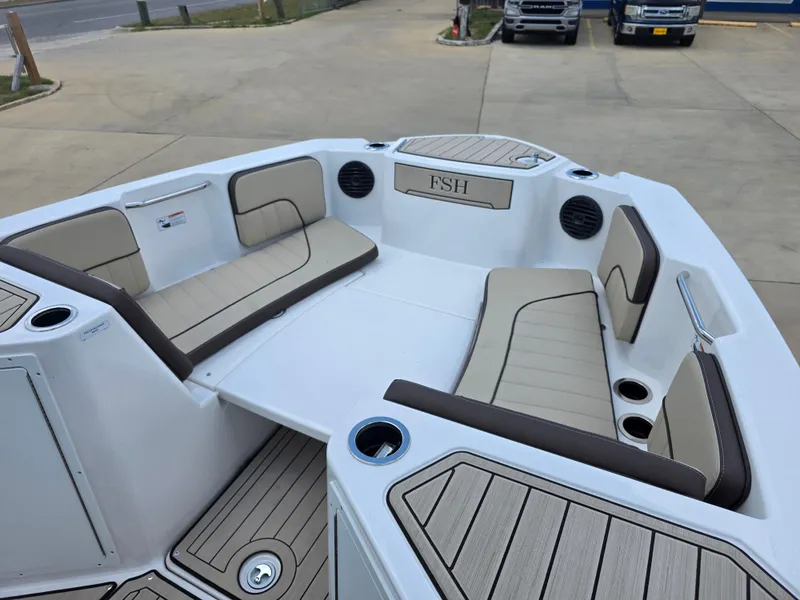 Slide: The Image of 2025 Yamaha Boats 222 FSH Sport E interior with beige seating and cup holders. - 9