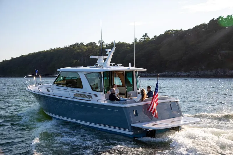 The Image of 2026 Sabre 43 Salon Express yacht cruising on scenic waters with passengers onboard. - 0