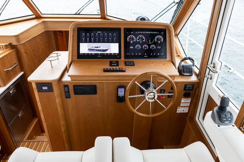 Slide: The Image of 2026 Sabre 43 Salon Express helm with modern navigation displays and wooden interior. - 11