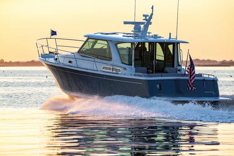 Slide: The Image of 2026 Sabre 43 Salon Express cruising on water at sunset, displaying American flag. - 22