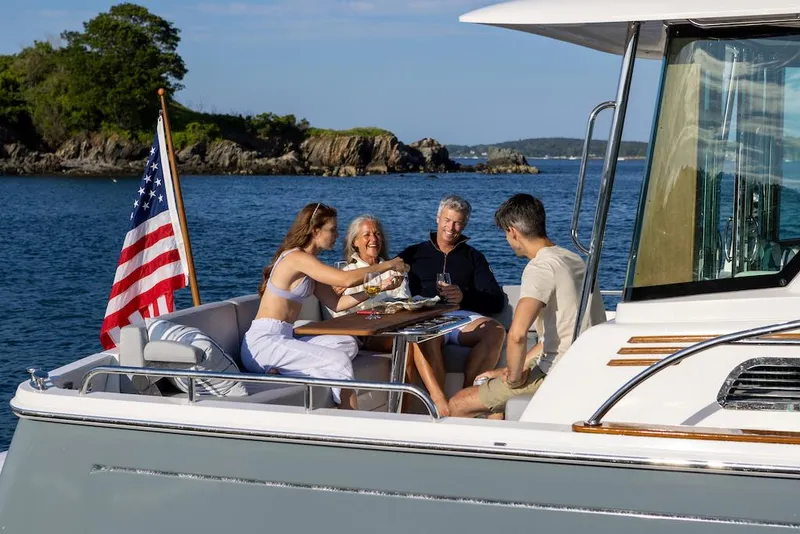 Slide: The Image of People enjoying a meal on a 2026 Sabre 43 Salon Express yacht, with scenic ocean views. - 4