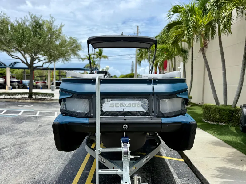 Slide: The Image of 2025 Sea-Doo Switch Cruise Limited 21 on trailer, parked outdoors with palm trees. - 6