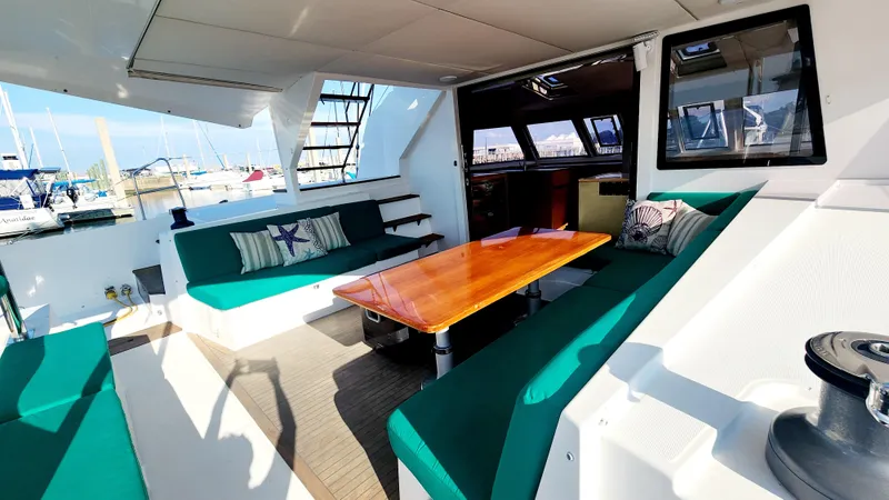 Slide: The Image of Spacious Nautitech 46 Fly 2017 yacht interior with green seating and wooden table. - 28