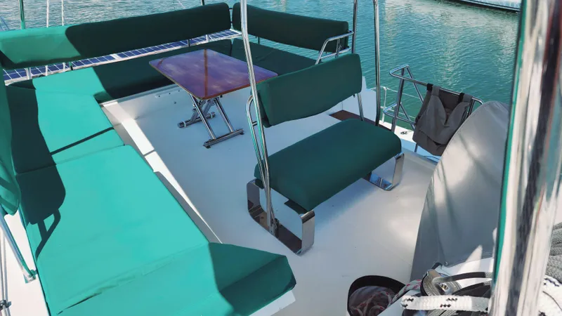 Slide: The Image of Flybridge seating area on a 2017 Nautitech 46 Fly catamaran, featuring green cushions and a wooden table. - 31