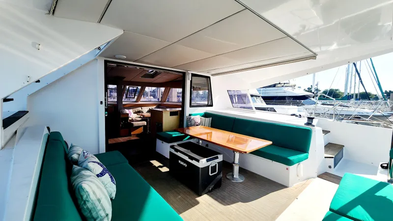 Slide: The Image of Spacious deck of 2017 Nautitech 46 Fly catamaran with green seating and wooden table. - 33
