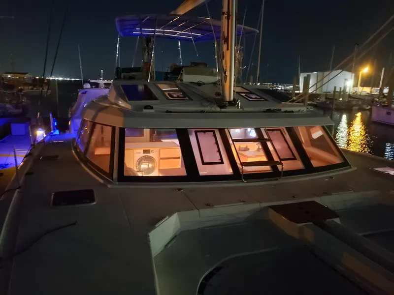 Slide: The Image of 2017 Nautitech 46 Fly catamaran docked at night, illuminated interior, marina background. - 42