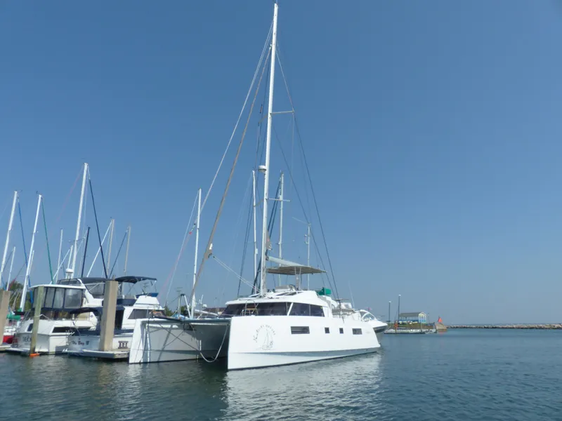 Slide: The Image of 2017 Nautitech 46 Fly catamaran docked in a marina under clear blue sky. - 46
