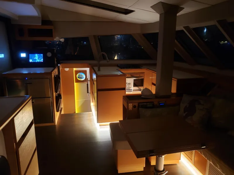 Slide: The Image of Interior of 2017 Nautitech 46 Fly catamaran, featuring modern kitchen and dining area at night. - 6