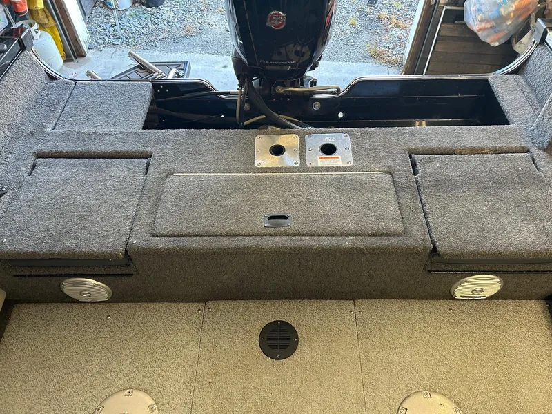 Slide: The Image of 2017 Lowe Fish & Ski FS1710 boat interior with carpeted deck and storage compartments. - 2