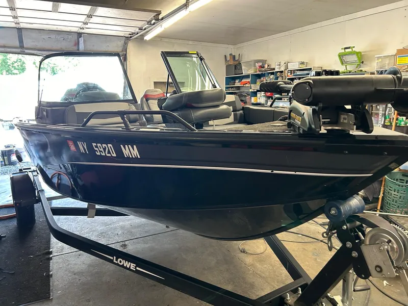 Slide: The Image of 2017 Lowe Fish & Ski FS1710 boat in garage, on trailer, with visible equipment. - 9