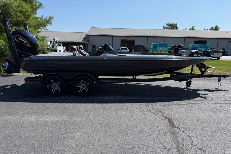 The Image of 2025 Skeeter ZXR21 boat on trailer, parked outdoors near industrial buildings. - 0