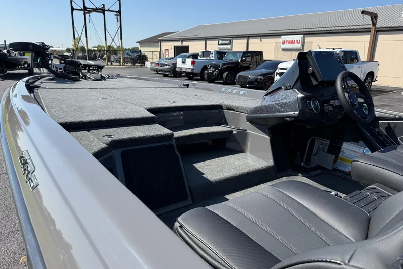 Slide: The Image of 2025 Skeeter ZXR21 boat interior with steering wheel, seats, and control panel in a dealership. - 16
