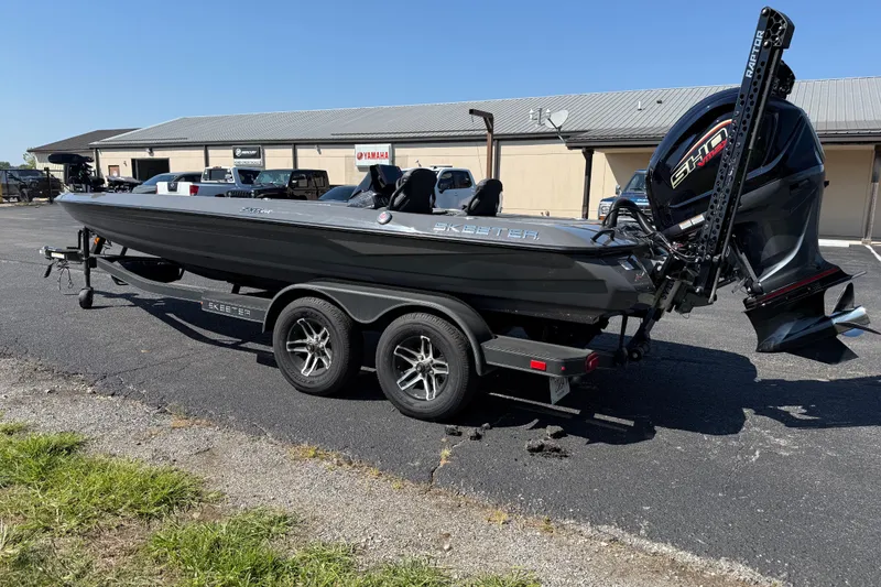 Slide: The Image of 2025 Skeeter ZXR21 boat on trailer, parked outdoors, featuring sleek design and powerful engine. - 2