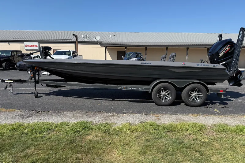 Slide: The Image of 2025 Skeeter ZXR21 boat on trailer, parked outdoors near a Yamaha building. - 3