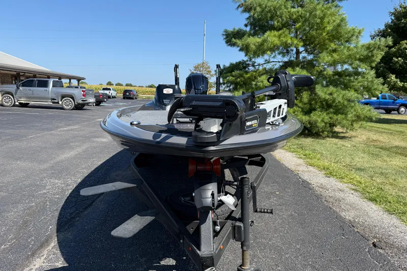 Slide: The Image of 2025 Skeeter ZXR21 boat on trailer in parking lot, surrounded by vehicles and trees. - 5