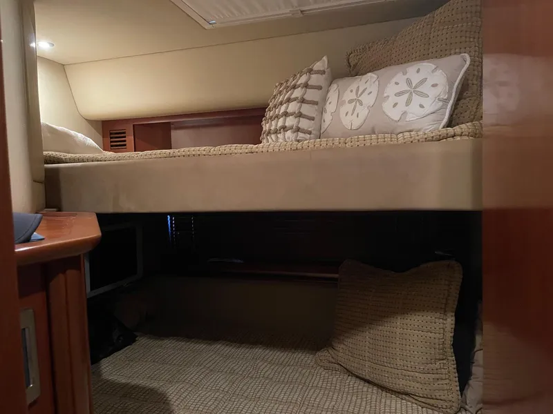 Slide: The Image of 2005 Sea Ray 500 Sundancer cabin with cozy bunk beds and decorative pillows. - 10