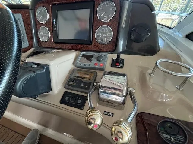 Slide: The Image of Control panel of a 2005 Sea Ray 500 Sundancer yacht with gauges and throttle levers. - 21
