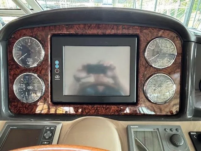 Slide: The Image of Dashboard of a 2005 Sea Ray 500 Sundancer boat with gauges and a central display. - 23