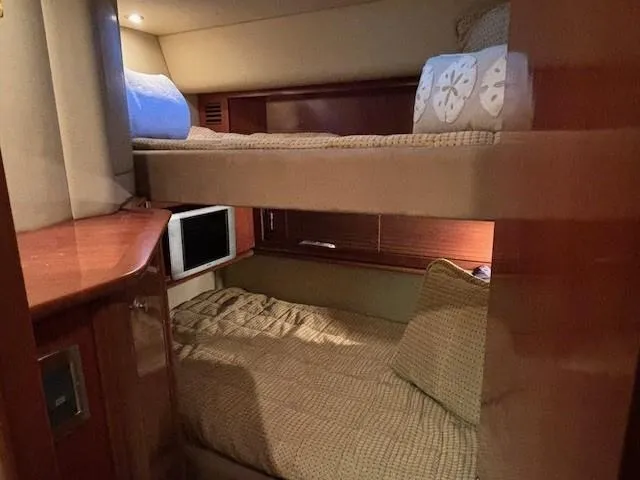 Slide: The Image of Interior cabin of 2005 Sea Ray 500 Sundancer with bunk beds and cozy decor. - 29