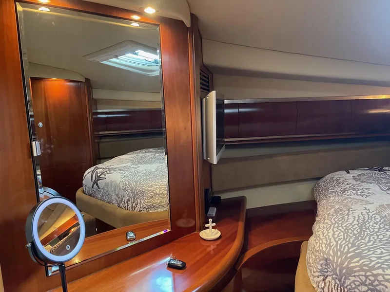 Slide: The Image of Luxurious 2005 Sea Ray 500 Sundancer cabin with elegant wood finishes and cozy bedding. - 8