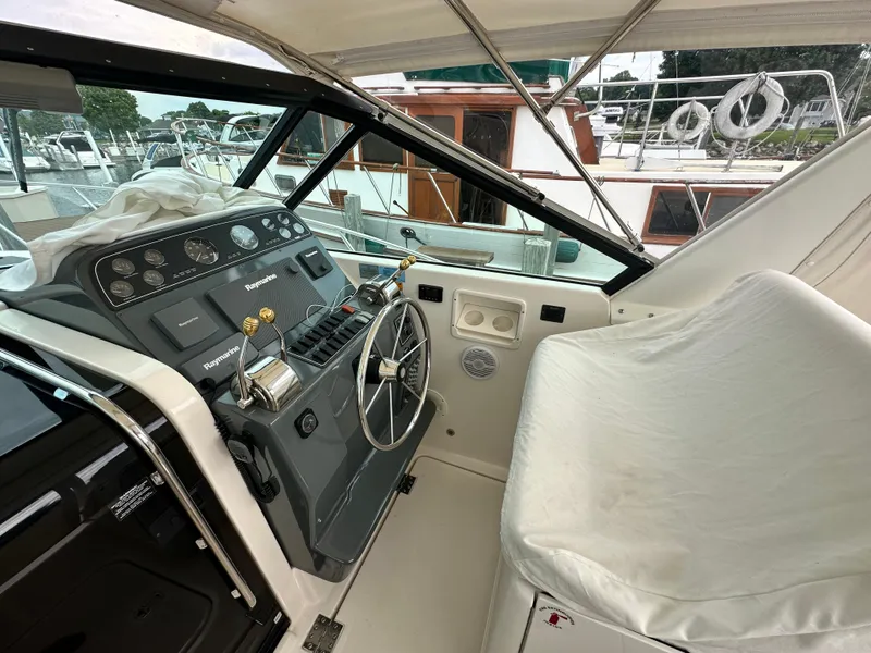 Slide: The Image of 2003 Tiara Yachts 3100 Open helm with steering wheel and navigation controls. - 13