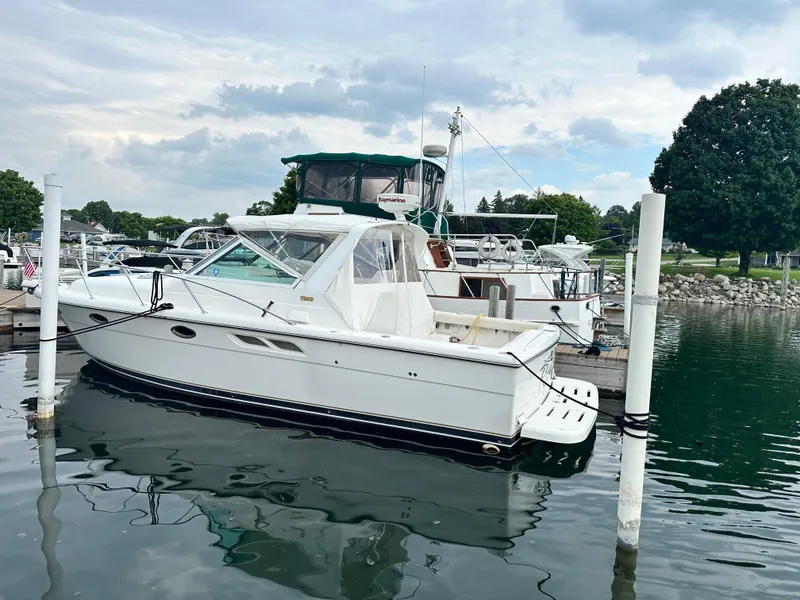 Slide: The Image of 2003 Tiara Yachts 3100 Open docked at a marina under cloudy skies. - 16