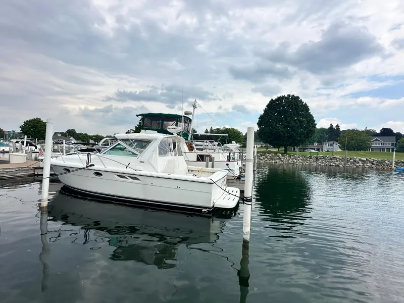 Slide: The Image of 2003 Tiara Yachts 3100 Open docked in a serene marina setting. - 17