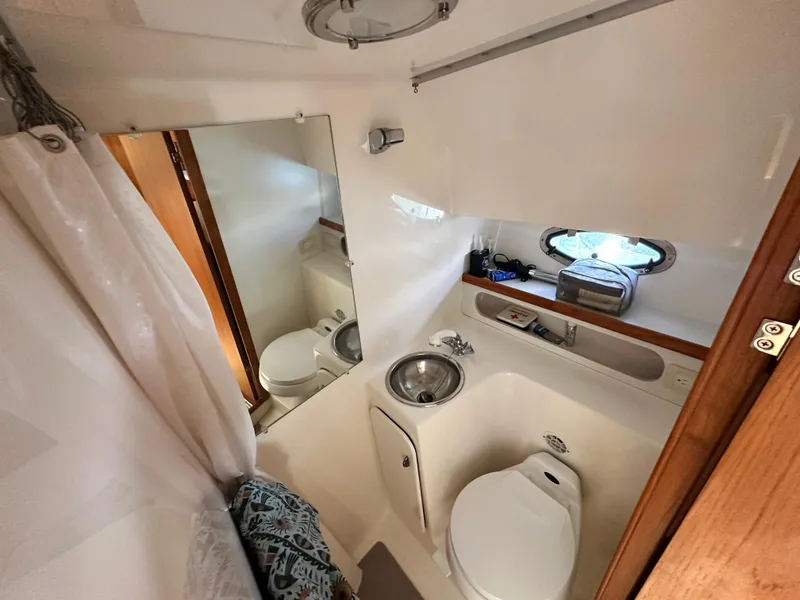 Slide: The Image of Bathroom interior of 2003 Tiara Yachts 3100 Open, featuring sink, toilet, and mirror. - 24