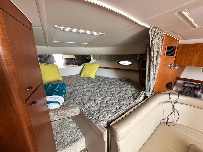 Slide: The Image of 2003 Tiara Yachts 3100 Open cabin interior with bed, wooden cabinets, and cozy seating area. - 26