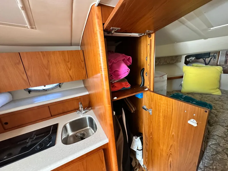 Slide: The Image of 2003 Tiara Yachts 3100 Open interior with kitchenette, sink, and storage cabinets. - 28