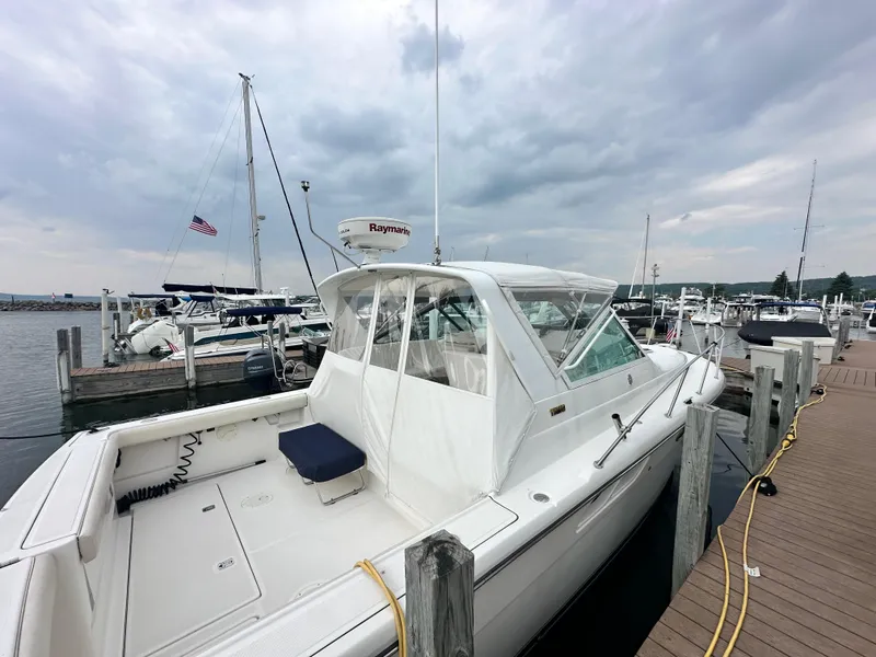 Slide: The Image of 2003 Tiara Yachts 3100 Open docked at marina under cloudy sky. - 3