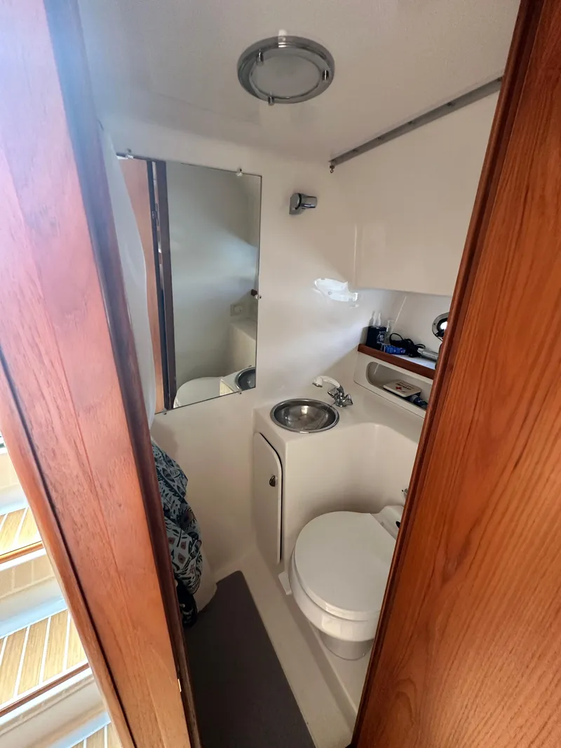 Slide: The Image of Compact bathroom in 2003 Tiara Yachts 3100 Open, featuring sink, toilet, and mirror. - 32