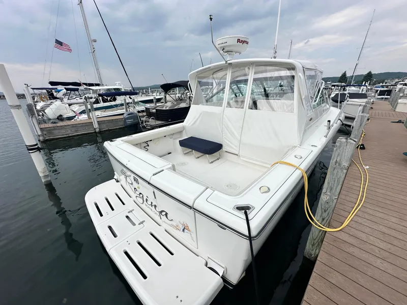 Slide: The Image of 2003 Tiara Yachts 3100 Open docked at marina, featuring spacious deck and sleek design. - 4