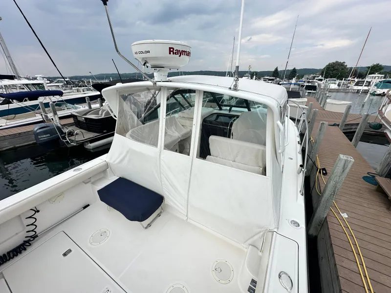 Slide: The Image of 2003 Tiara Yachts 3100 Open docked, featuring a spacious deck and Raymarine radar. - 5